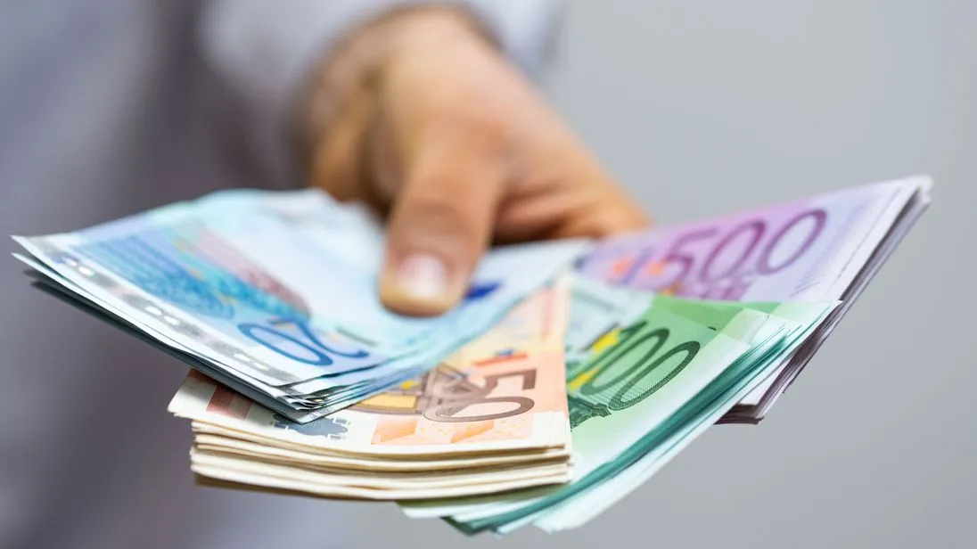 Mann hält diverse Euro-Banknoten in der Hand
